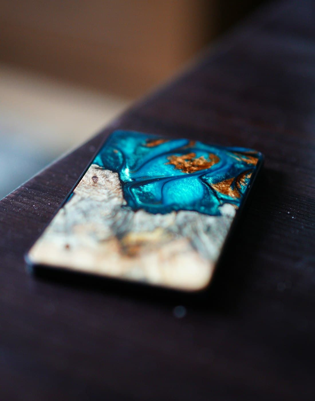 A finished teal and gold resin art piece